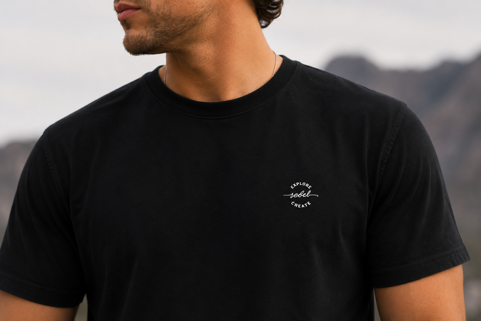 Black Founder’s Edition tee with small Explore Rebel Create chest mark